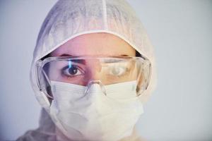 portret van vrouw dokter wetenschapper in laboratorium jas, defensief eyewear en masker foto
