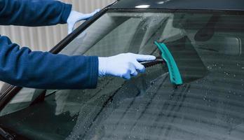 mannetje arbeider in uniform het wassen nieuw modern auto. opvatting van onderhoud foto