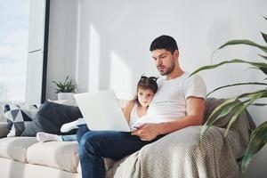 gelukkig vader met zijn dochter uitgeven vrij tijd met laptop Bij huis samen foto