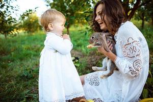 mooi jong vrouw met met konijn en weinig schattig meisje foto