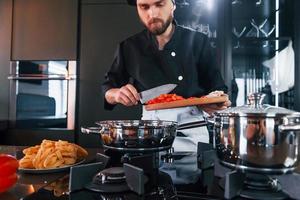 professioneel jong chef koken in uniform werken Aan de keuken foto