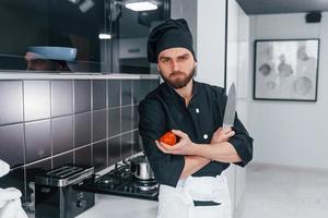 professioneel jong chef koken in uniform staand Aan de keuken foto