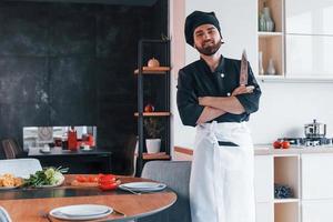 professioneel jong chef koken in uniform maken salade Aan de keuken foto