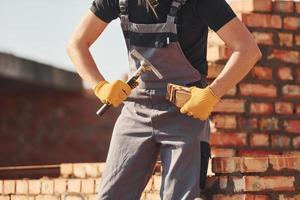 bezig met steen muur. bouw arbeider in uniform en veiligheid uitrusting hebben baan Aan gebouw foto