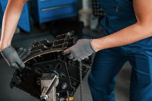 dichtbij omhoog visie van professioneel klusjesman in garage dat werken met gebroken auto- motor foto