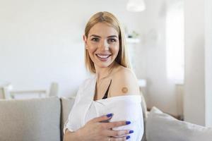 jong vrouw met Zelfklevend verband Aan haar arm na corona virus vaccin. eerste hulp. medisch, apotheek en gezondheidszorg concept. foto