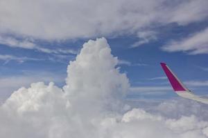 visie van vliegtuig. de vleugel van een vliegtuig en verbazingwekkend wit wolken Bij blauw lucht foto