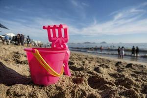 emmer en lepel in de zand Aan de strand Aan vakantie foto