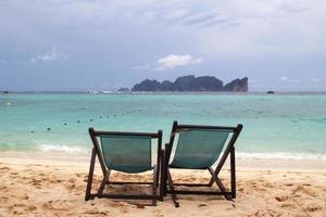 reizen naar eiland phi phi, Thailand. twee stoelen Aan een strand in de buurt naar zee. foto