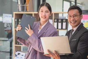 marketing, financieel, boekhouding, planning, twee mannetje en vrouw marketeers gebruik bedrijf documenten en gebruik laptop computers naar Vermelding gegevens naar analyseren bedrijf winsten. foto