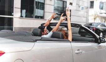 gelukkig jong paar hebben pret in converteerbaar auto Aan mooi zomer dag foto