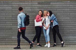 drie Dames en een vent is buitenshuis in de buurt gebouw Bij dag foto