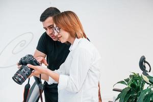 Mens in zwart kleren aan het kijken foto's Aan de vrouwelijk fotograaf camera foto