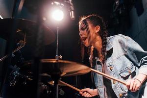 Toneelstukken trommels. jong mooi vrouw performer repeteren in een opname studio foto