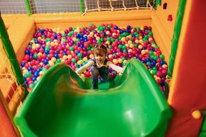 gelukkig weinig meisje in gewoontjes kleren hebben pret in kinderen spel complex foto