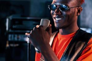 hebben vocale oefening. jong Afrikaanse Amerikaans performer repeteren in een opname studio foto