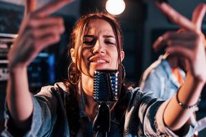 vent Toneelstukken gitaar, meisje zingt. Afrikaanse Amerikaans Mens met wit meisje repeteren in de studio samen foto