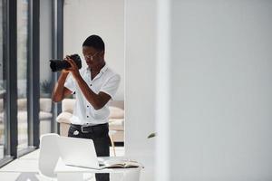 testen camera. jong Afrikaanse Amerikaans Mens in formeel kleren is in de kantoor foto