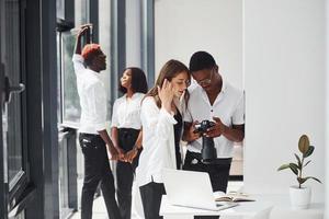 op zoek Bij de camera. groep van Afrikaanse Amerikaans bedrijf mensen werken in kantoor samen foto