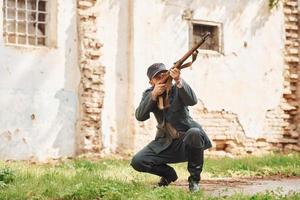 ternopil, Oekraïne - juni 2020 upa oekraïens opstandeling leger film filmen. afbeeldingen van achter de schermen. jong soldaat met wapen in de buurt oud gebouw foto