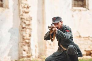 ternopil, Oekraïne - juni 2020 upa oekraïens opstandeling leger film filmen. afbeeldingen van achter de schermen. jong soldaat met wapen in de buurt oud gebouw foto