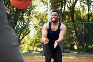 Afrikaanse Amerikaans Mens met meisje Toneelstukken basketbal Aan de rechtbank buitenshuis foto