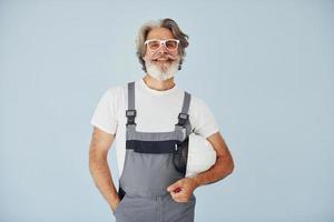 klusjesman klaar voor werk. senior elegant modern Mens met grijs haar- en baard binnenshuis foto