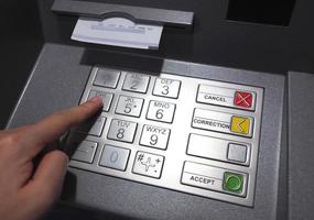Geldautomaat knop dichtbij omhoog en papier transactie storting betalen uitglijden en hand. foto