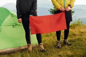 vrouw en Mens Holding rood vlag. majestueus Karpaten bergen. mooi landschap van onaangeroerd natuur foto