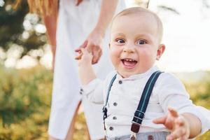 jong moeder met haar weinig zoon is buitenshuis in de Woud. mooi zonneschijn foto