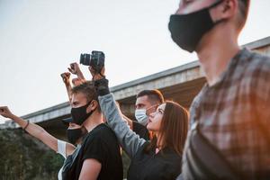 fotograaf met camera. groep van protesteren jong mensen dat staand samen. activist voor menselijk rechten of tegen regering foto