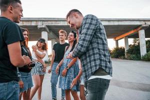 pratend en lachend. groep van jong vrolijk vrienden hebben pret samen. partij buitenshuis foto