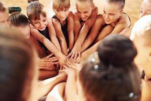 veel van mensen. groep van vrouw kinderen beoefenen atletisch opdrachten samen binnenshuis foto