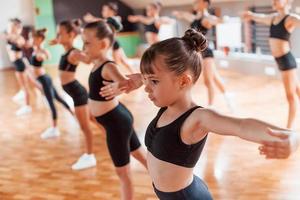 actief levensstijl. groep van vrouw kinderen beoefenen atletisch opdrachten samen binnenshuis foto