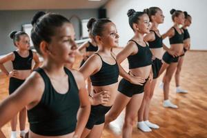 groep van vrouw kinderen beoefenen atletisch opdrachten samen binnenshuis foto