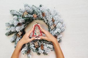 vrouw handen houdt speelgoed. top visie van Kerstmis feestelijk structuur met nieuw jaar decoraties foto