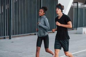 Europese Mens en Afrikaanse Amerikaans vrouw in sportief kleren hebben training samen foto