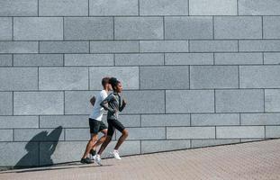 Europese Mens en Afrikaanse Amerikaans vrouw in sportief kleren hebben training samen foto