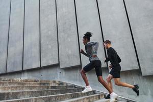 Europese Mens en Afrikaanse Amerikaans vrouw in sportief kleren hebben training samen foto