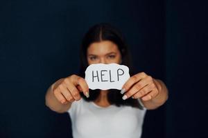 jong bang vrouw houdt teken en vragen voor helpen. opvatting van huiselijk geweld foto