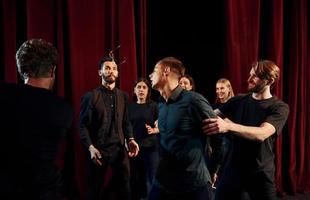 werken samen. groep van acteurs in donker gekleurde kleren Aan repetitie in de theater foto