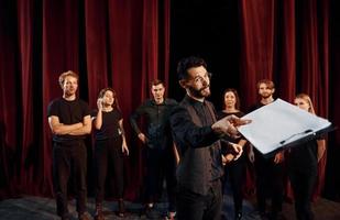 uitdrukbaar vent beoefenen zijn rol. groep van acteurs in donker gekleurde kleren Aan repetitie in de theater foto