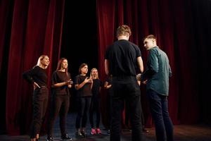 groep van acteurs in donker gekleurde kleren Aan repetitie in de theater foto