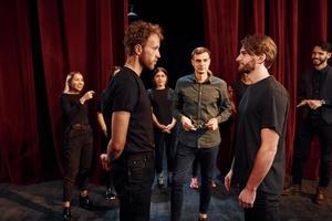 oog contact oefening. groep van acteurs in donker gekleurde kleren Aan repetitie in de theater foto