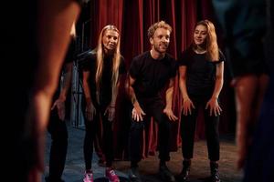 praktijk in voortgang. groep van acteurs in donker gekleurde kleren Aan repetitie in de theater foto