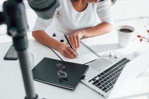 camera opname meisje. jong vrouw freelancer werken binnenshuis in de kantoor Bij dag foto