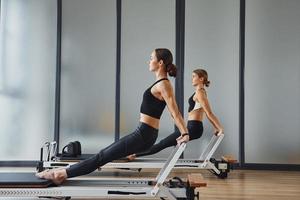 handen kracht. twee Dames in sportief slijtage en met slank lichamen hebben geschiktheid yoga dag binnenshuis samen foto