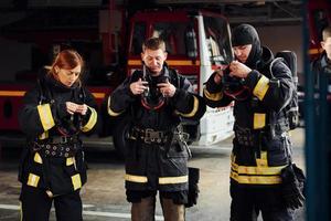 vervelend beschermend uniform. groep van brandweerlieden dat is Aan station foto