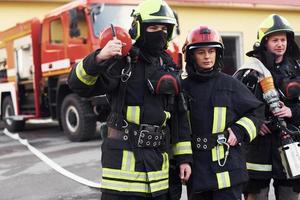groep van brandweerlieden in beschermend uniform dat is Aan station foto