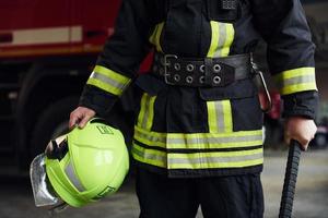 mannetje brandweerman in beschermend uniform staand in de buurt vrachtauto foto